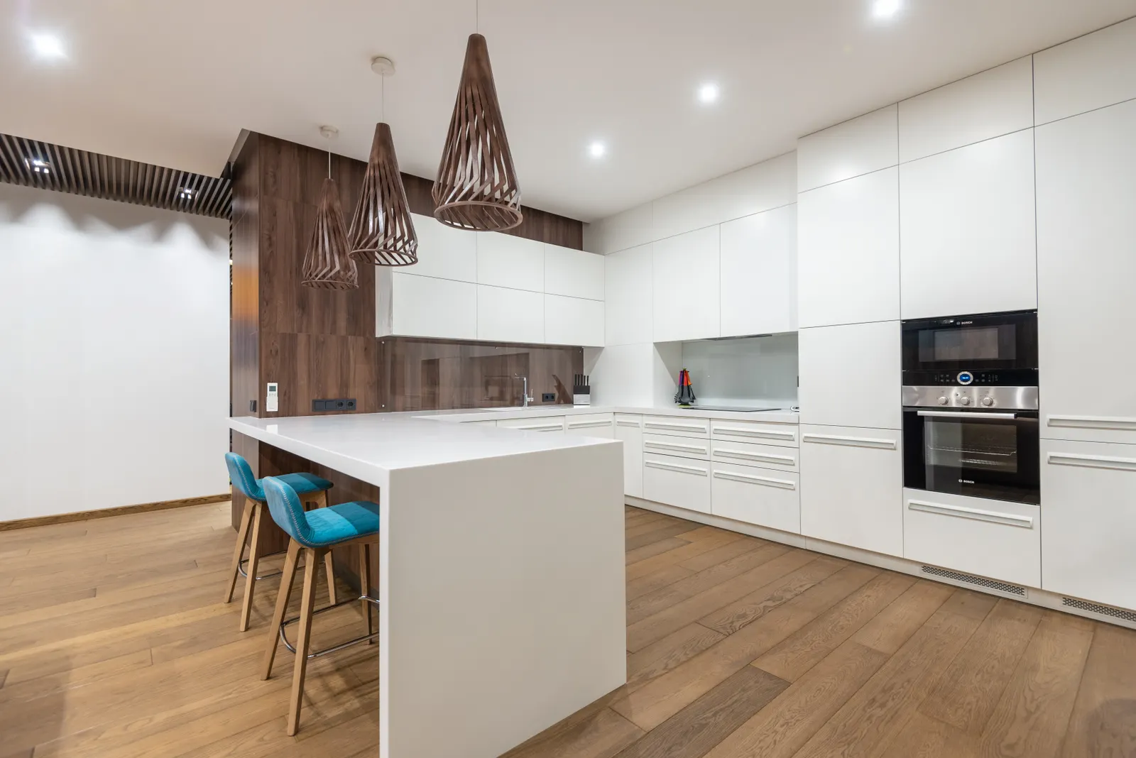 Bright modern kitchen with a central island, pendant lighting, and warm wood finishes